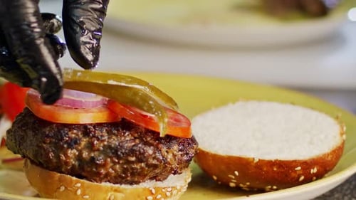 Chef Assembling Gourmet Hamburger on Plate