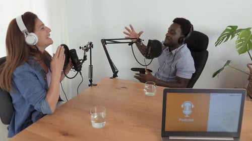 Multiracial people recording a podcast using microphone and laptop from home studio
