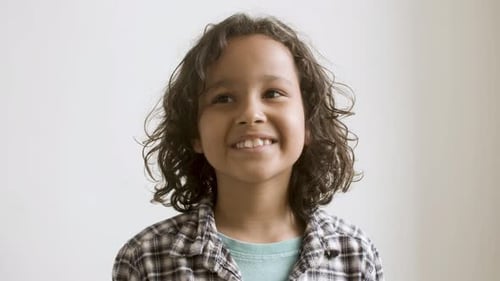 Young Curlyhaired Boy Smiling at Camera