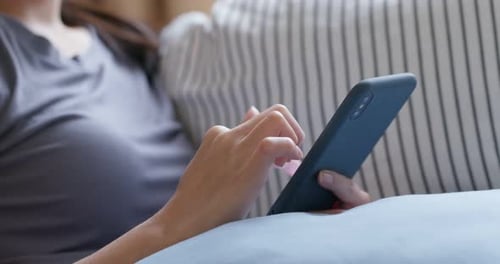Adult Hands Scrolling on a Smartphone While Relaxing