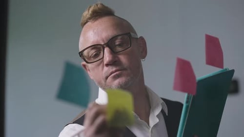 Adult with Mohawk Writing on Sticky Note