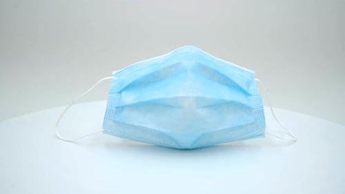 Blue Surgical Mask on White Surface Rotating