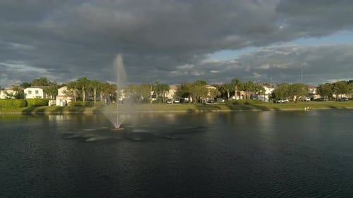 Aerial of a lake with a fountain near houses
