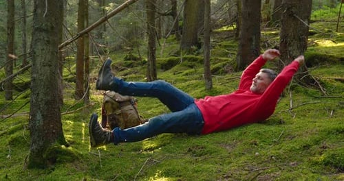 Tourist Guy Resting on Moss in a Beautiful Forest