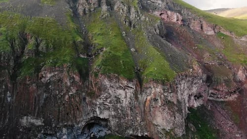 Big Brown Sharp Cliffs with Grass on Top and River in Canyon