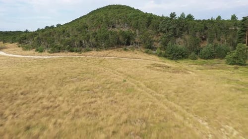 AERIAL: Flying Over Dry Meadow and Over Mountain to Horizon with Sea Visible in Background