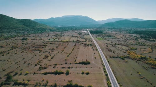 Aerial View Empty Asphalt Road on the Plateau Between Green Fields Highland Way