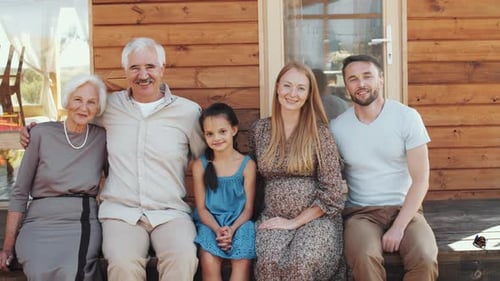 Multi-Generational Family Posing Outside Wooden Home