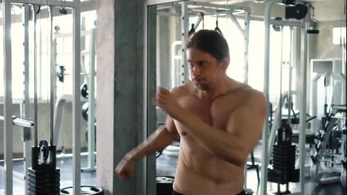 Shirtless Muscular Man Practicing Shadow Boxing at the Gym