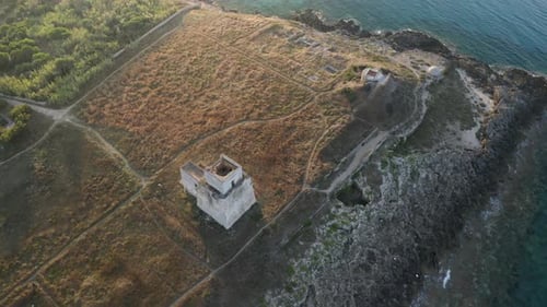 Aerial shot of coastline with a small castle on the beach