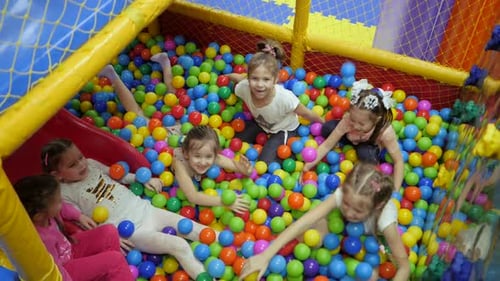Children's Playroom. Children Play in a Dry Basin Filled with Plastic Colored Balls