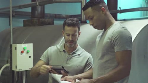 Industrial plant workers looking at blueprint