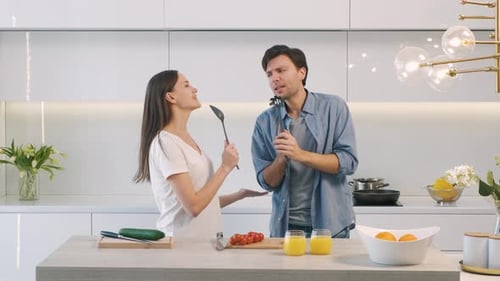 Happy Couple Singing Together in Modern Kitchen