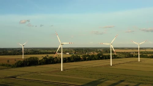 Aerial View of Wind Turbines Standing Field at Sunset Producing Clean Energy