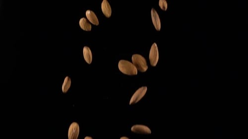 Almonds Falling in Slow Motion on Black Background
