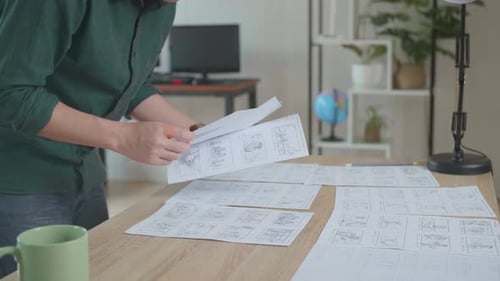 Designer Works On A Storyboard, Looks At His Sketches And Concepts, Choosing The Best Drawings