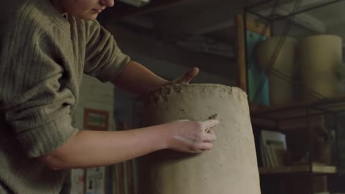 Woman Sculpting Clay in Pottery Workshop