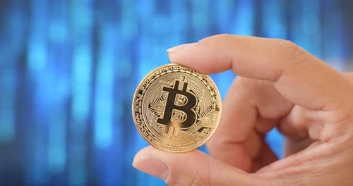 Hand Holding Bitcoin Gold Coin Close Up