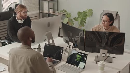 Equipe diversificada de programadores trabalhando em computadores