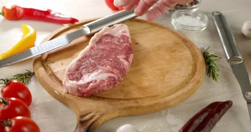 Two Raw Steaks Placed On Cutting Board