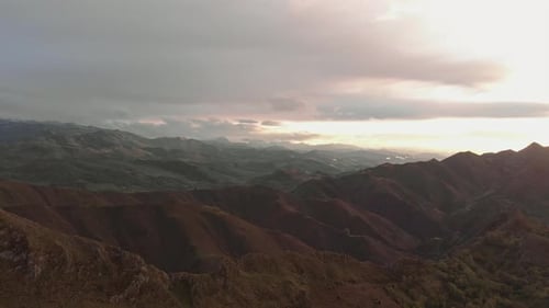 Drone shot over a mountain range at sunset