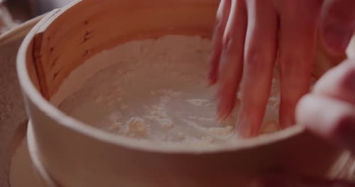 Hands Sifting Flour in a Sieve, Close Up