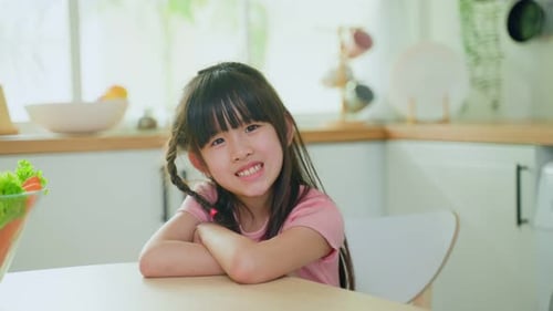 Smiling Child Sitting at Kitchen Table