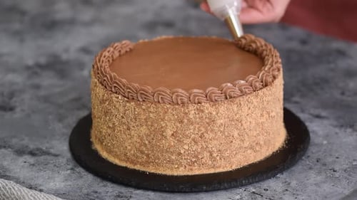 Chocolate Cake Being Decorated with Chocolate Frosting