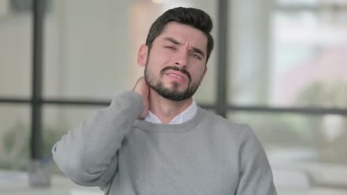 Man Rubbing His Neck in Pain