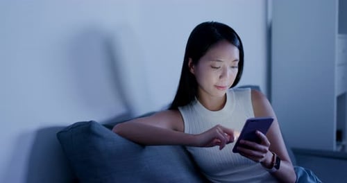 Woman Uses Phone at Night at Home
