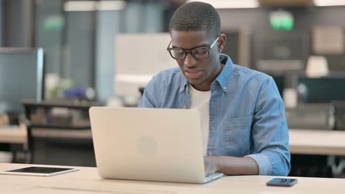 Stressed Young Man Working at Computer in Office