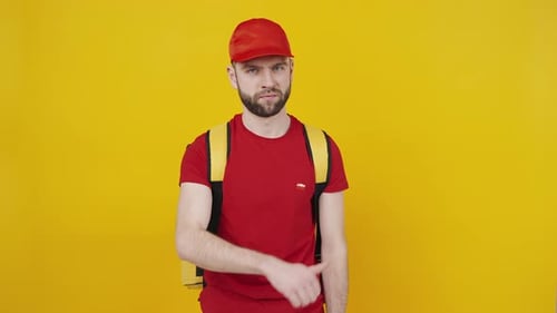 Bearded Man with Backpack Gesturing Towards Himself