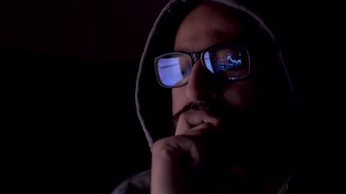 Close-up male in glasses reflecting financial stock data.Stock market trader looking at graph of sha