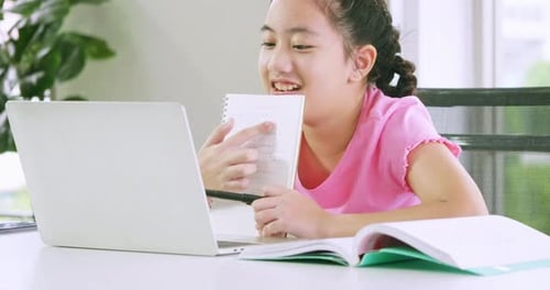 Ein Mädchen, das ihre Schularbeit mit Laptop erledigt. Fernunterricht und Online-Bildungskonzept.