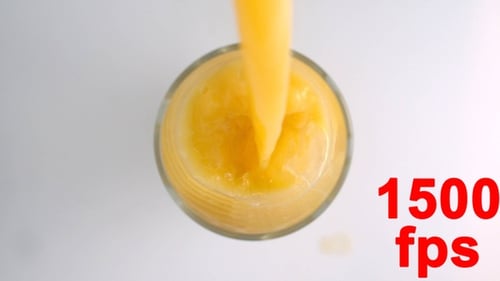 Glass Being Filled with Orange Juice