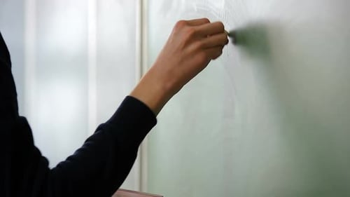 Writing on a Green Chalkboard in Classroom