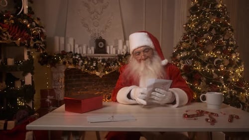 Santa Claus Reading a Letter Near Christmas Tree