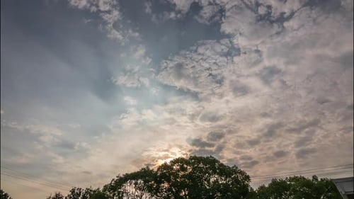Fluffy Clouds Moving Across Sky at Sunrise