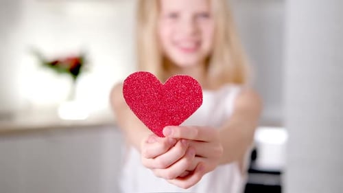 Red Heart Close Up in Hands of Little Blonde Smiling Girl on Valentines Day