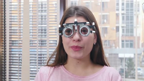 Junge lächelnde Frau sitzt im Optometrie-Gerät für Sehtest