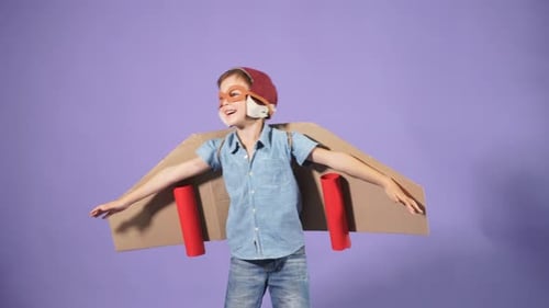 Pilot Boy mit Pappflugzeug isoliert über blauem Hintergrund