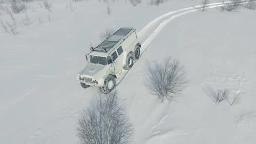 Six-Wheeled Truck Driving Through Snowy Winter Landscape