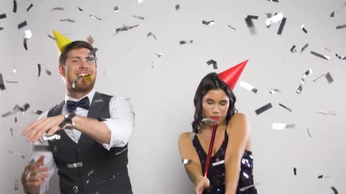 Couple Celebrates with Party Hats and Confetti