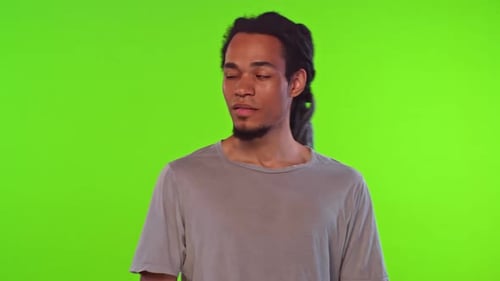 Young Adult Winking with Dreadlocks on Green Screen