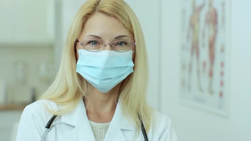 Happy European Woman Doctor with Glasses in Medical Mask Wearing White Medical Coat and Stethoscope