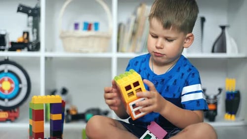 Young Boy Builds with Colorful Blocks at Home