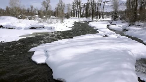 Fluss fließt durch Tiefschnee