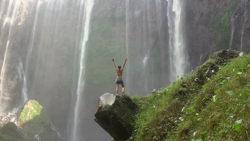 Woman Enjoying Epic Waterfall View in Lush Tropics