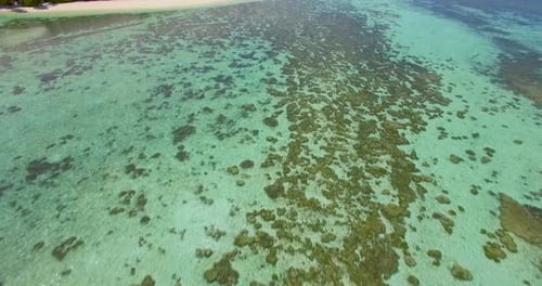 Aerial drone view of a coral reef and scenic tropical island in the Maldives.