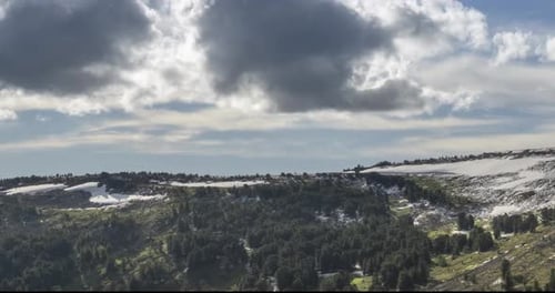 Time Lapse of Cloudscape Behind of the Mountains Top. Snow, Rocks, Cliffs and Deep Blue Sky. High